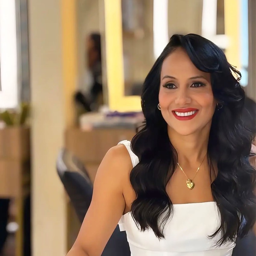 Cliente sorrindo com cabelo ondulado e vestido branco